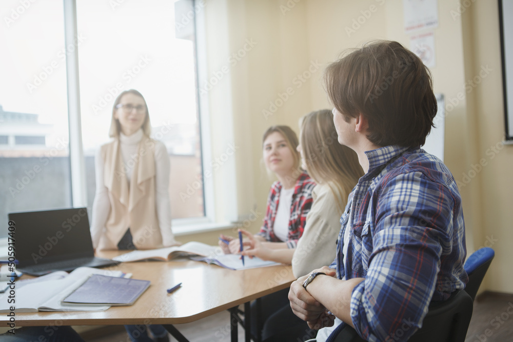 Male student sitting relaxed, enjoying seminar with university teacher, copy space Male student sitting relaxed, enjoying seminar with university teacher, copy space