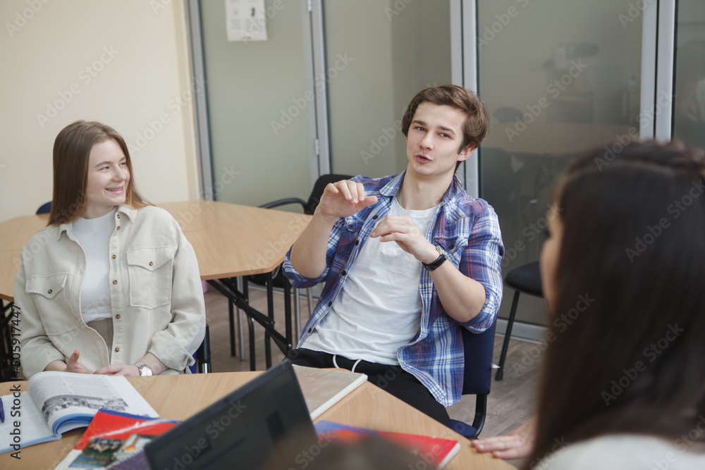 Fototapeta premium Handsome young male student talking during class at college