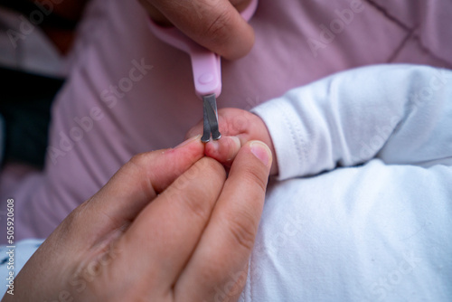 Detalle de manos de mam   cortando u  as de manos de beb   con tijeras