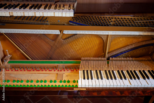 Disassembled upright piano for regulation, cleaning, repair. Interior of a piano. Piano keys maintenance. Piano cast iron frame with strings. Piano sound board. Celesta photo