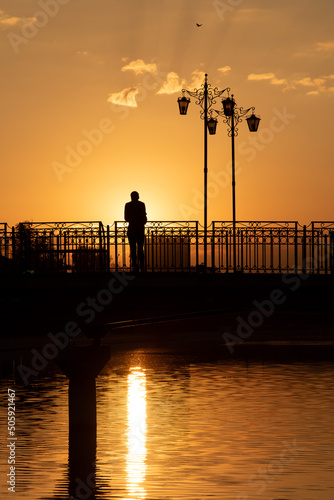 Beautiful sunset in the city. The man on the bridge.