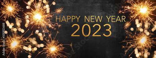 HAPPY NEW YEAR 2023 / New Year's Eve Party background greeting card - Sparklers and bokeh lights, on dark black night sky