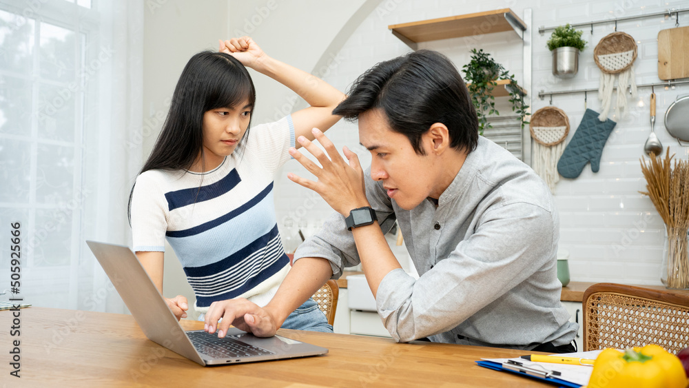 Stressed unhappy couple arguing about huge expenses with laptop and papers, angry wife blaming husband of overspending debt, family having conflict fight about wasting money financial problem at home. Stressed unhappy couple arguing about huge expenses with laptop and papers, angry wife blaming husband of overspending debt, family having conflict fight about wasting money financial problem at home.