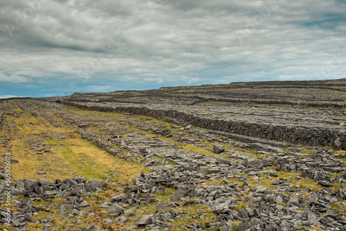 Stunning nature scenery of Aran island, county Galway, Ireland. Dry stone fences and blue cloudy sky. Warm sunny day. Irish nature landscape scene. Popular travel and tourism area.