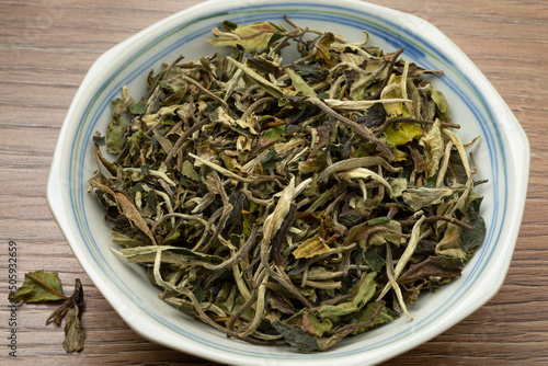 Bowl with dried Chinese Bai Mudan tea leaves close up 