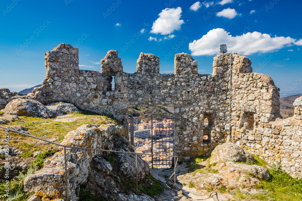 The small village of Tolfa, in Lazio. The remains of the ancient walls of the fortress that stands on top of the cliff. The ruins of the castle and the houses of the town located downstream. The small village of Tolfa, in Lazio. The remains of the ancient walls of the fortress that stands on top of the cliff. The ruins of the castle and the houses of the town located downstream.