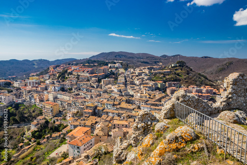 Fototapeta Naklejka Na Ścianę i Meble -  The small village of Tolfa, in Lazio. The view of the town perched on the mountain, from the top of the ruins of the castle walls. The roofs of the houses with red and orange tiles.