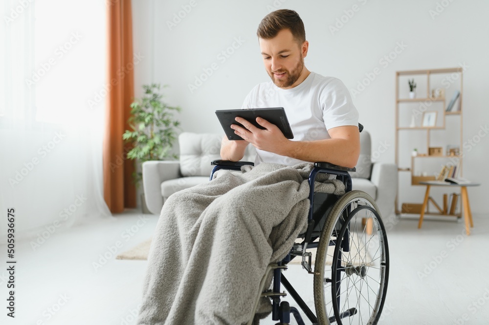 Modern young disabled man in wheelchair having video call Modern young disabled man in wheelchair having video call