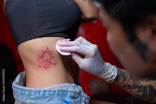 Tattoo artist cleaning the skin with soap after doing in the room. Tattooing concepts. © somchairakin