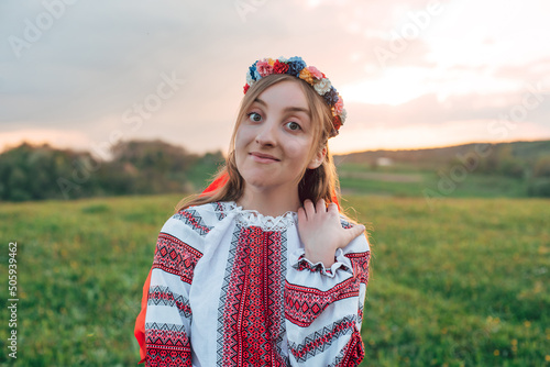 horizontal portrait of young beautiful Ukrainian woman in vyshyvanka  - ukrainian national clothes outdoors in countryside during sunset. Stand with Ukraine  