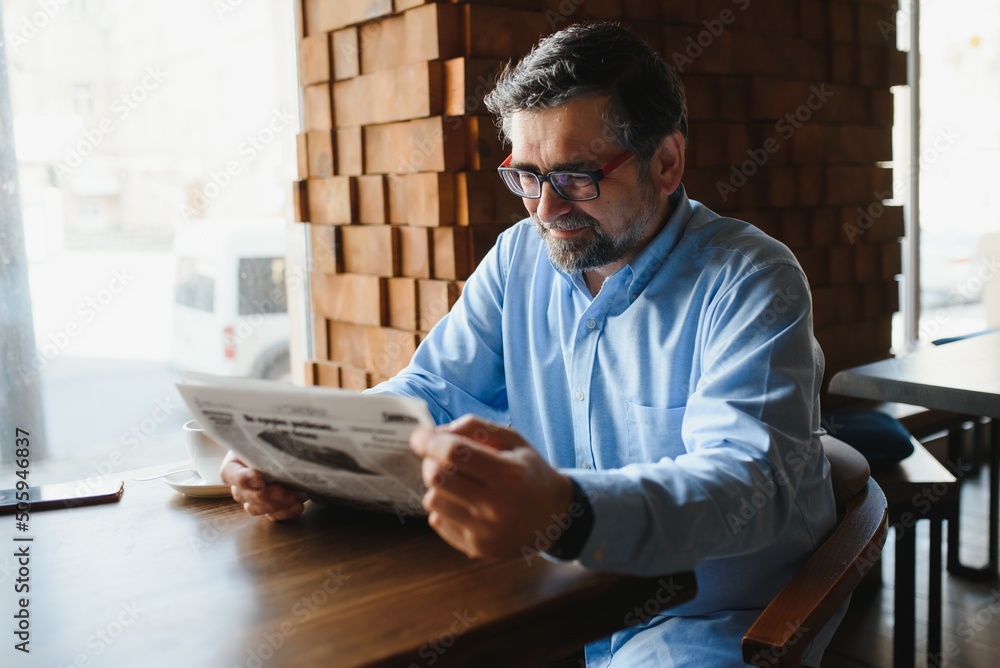Newspaper in the morning. Senior businessman at his office riding newspapers. Newspaper in the morning. Senior businessman at his office riding newspapers.