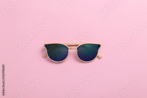 Stylish sunglasses on pink background. Top view