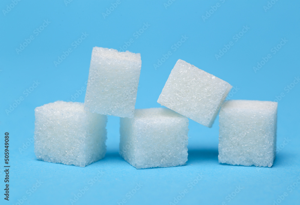 White sugar cubes on a turquoise background White sugar cubes on a turquoise background
