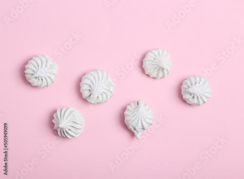 Sweet meringue on a pink background. Top view. Flat lay