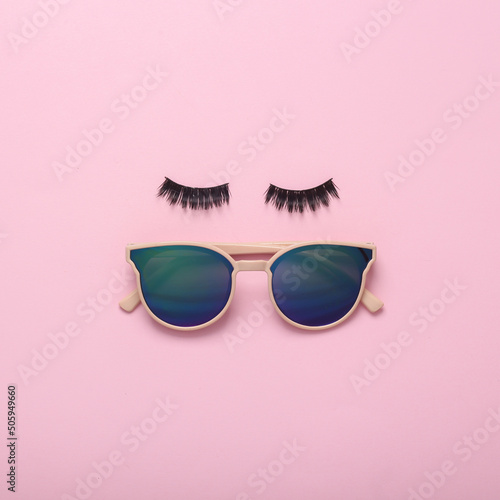 Eyelashes with sunglasses on a pink background. Minimal creative layout, beauty concept