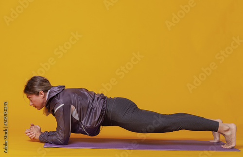 Sport woman trainin on yellow studio background