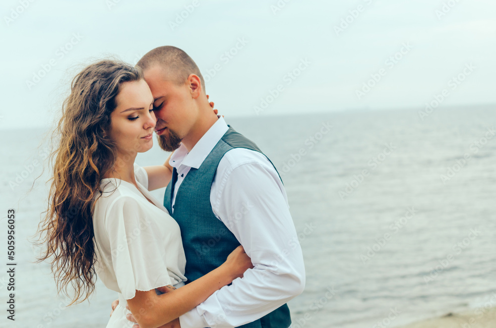 man and woman hugging by the sea on their honeymoon man and woman hugging by the sea on their honeymoon