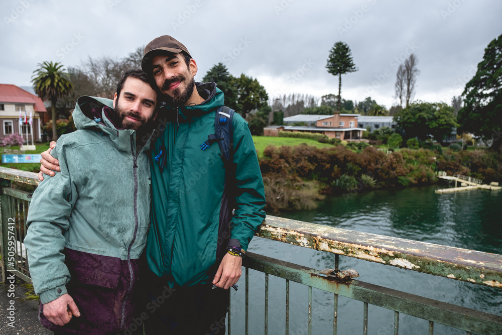 Obraz na plátně Two happy, young, caucasian, bearded and handsome brothers with jacket, cap and