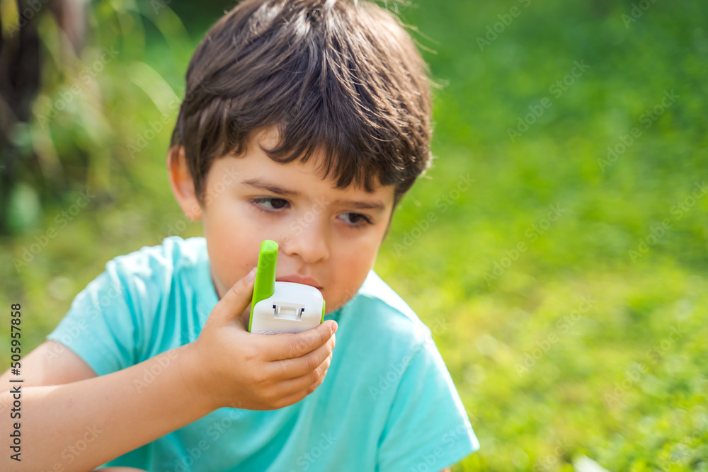 Small boy,kid,child play in walkie-talkie.Walkie Talkies with channels.Game of detectives,spies.Children talk,say messages at distance.Communication with parents. Forest,park,hike.Finding lost people Small boy,kid,child play in walkie-talkie.Walkie Talkies with channels.Game of detectives,spies.Children talk,say messages at distance.Communication with parents. Forest,park,hike.Finding lost people