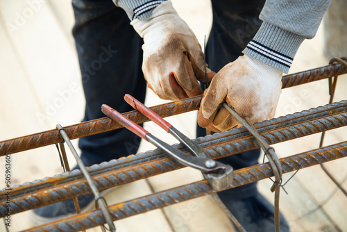 man cutting reinforcement mesh at building site