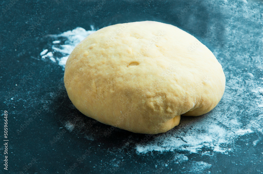 loaf with dough on a board with flour. round bread on a dark texture. bread baking concept. loaf with dough on a board with flour. round bread on a dark texture. bread baking concept.