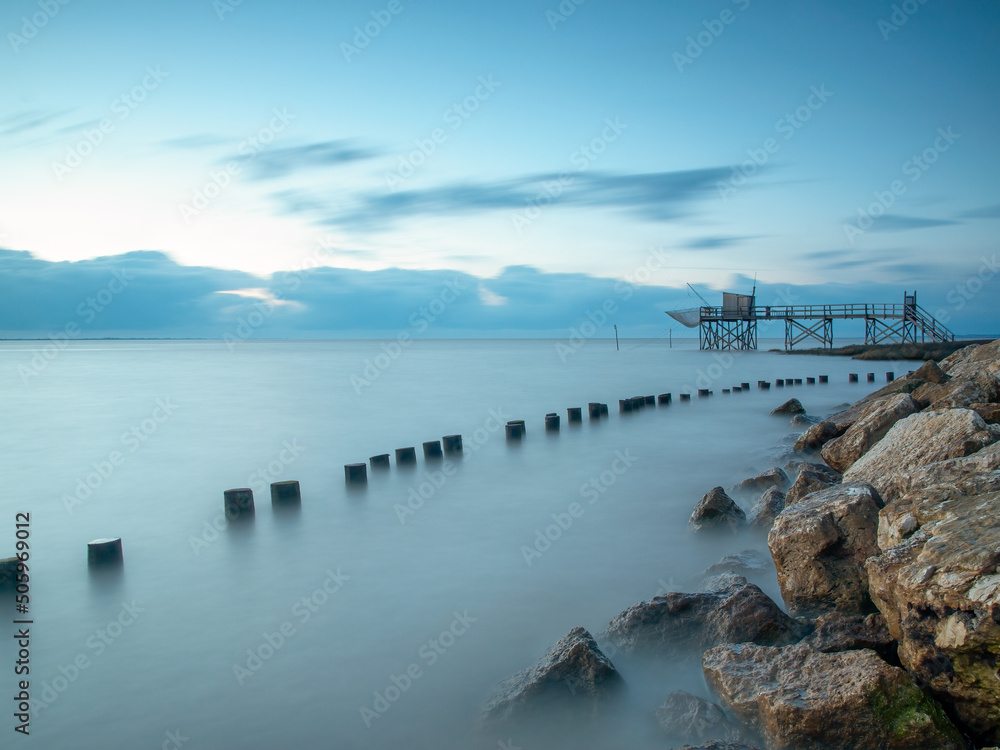 Blue hour sunset with fishing hut in calm seas on Atlantic coast, Charente Maritime, France. 