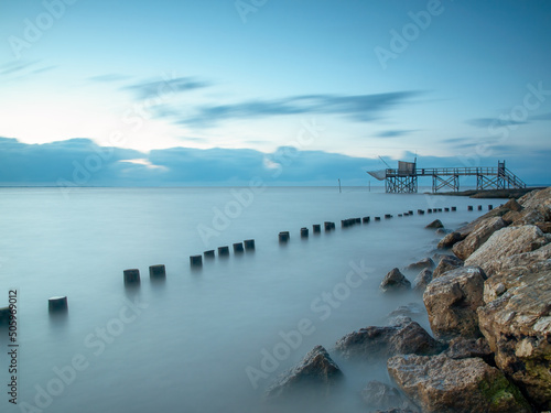 Blue hour sunset with fishing hut in calm seas on Atlantic coast, Charente Maritime, France. 