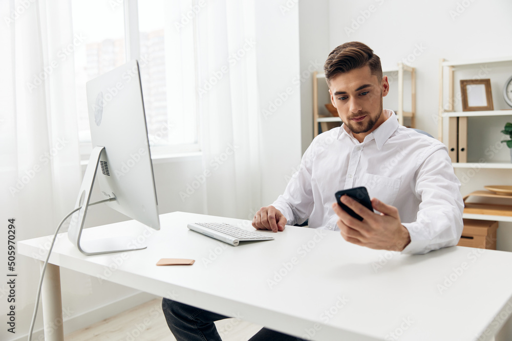manager sitting at a desk in front of a computer with a keyboard workplace manager sitting at a desk in front of a computer with a keyboard workplace