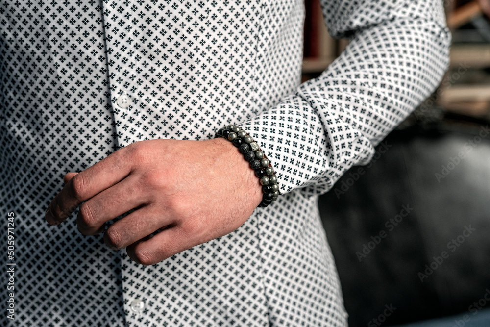 Business style, men's bracelets on the hand. White shirt, close-up Business style, men's bracelets on the hand. White shirt, close-up