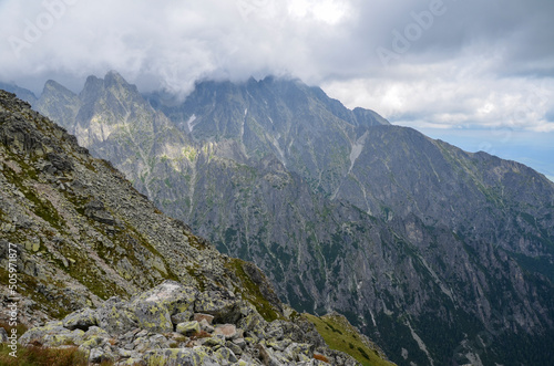Sharp peaks and rocks on mountainside surrounded by clouds in High Tatras, Slovakia