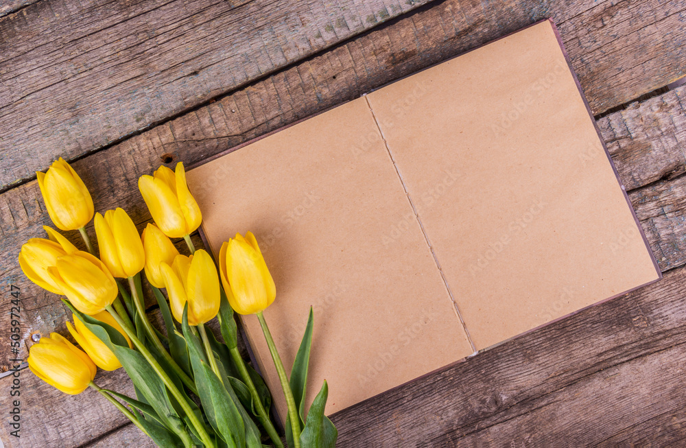 Blank open book with yellow tulips. Copy space