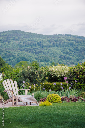 Miejsce na wypoczynek, fotel ogrodowy na tarasie w zielonym ogrodzie z widokiem na góry