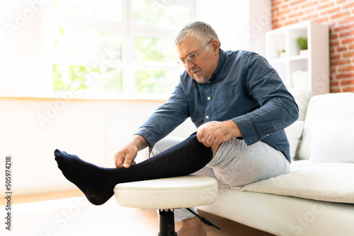 Man Putting On Medical Compression Stockings photo