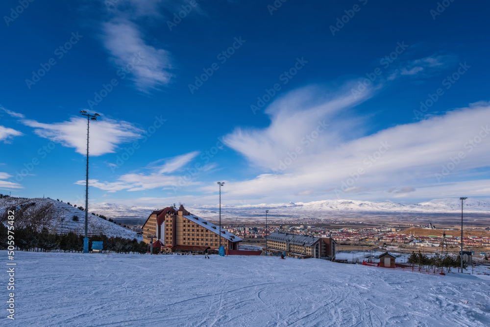 Palandoken Mountain, Erzurum Turkey. January, 2021: Ski slopes and Ski lifts. Small pine trees with snow. Mountain skiing and snowboarding. View of Erzurum hotels from Palandoken mountain