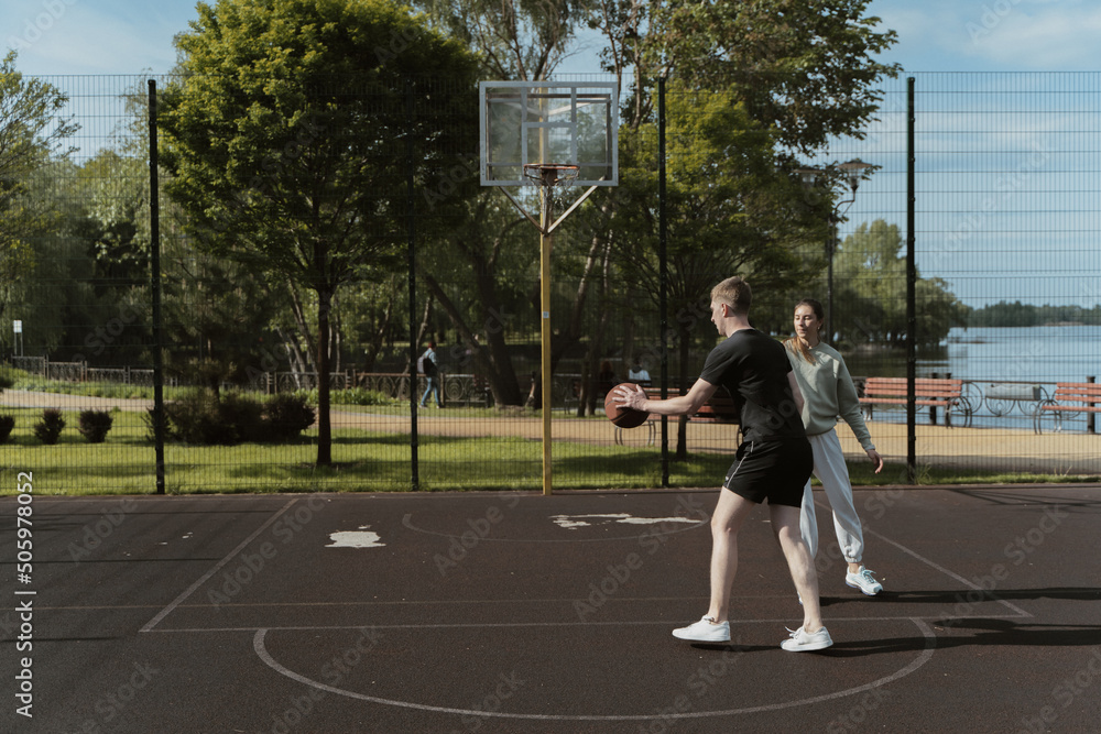 girl and boy playing basketball on the basketball court