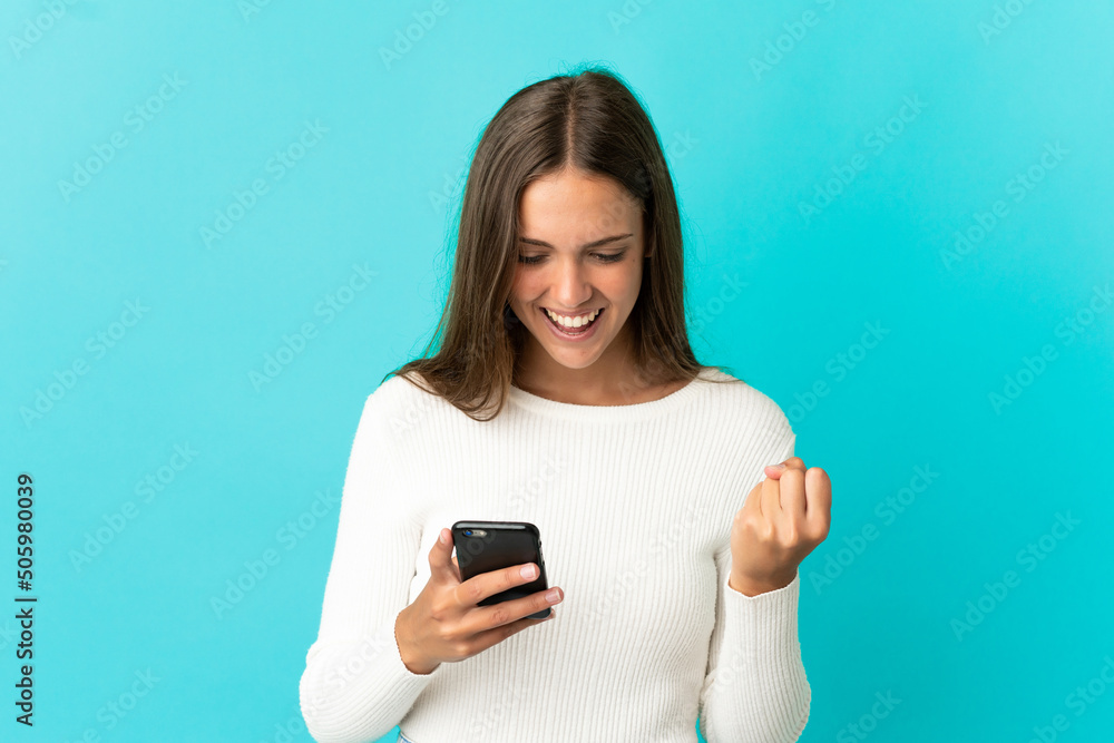 Young woman over isolated blue background surprised and sending a message Young woman over isolated blue background surprised and sending a message