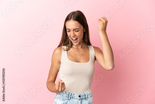 Young woman over isolated pink background celebrating a victory