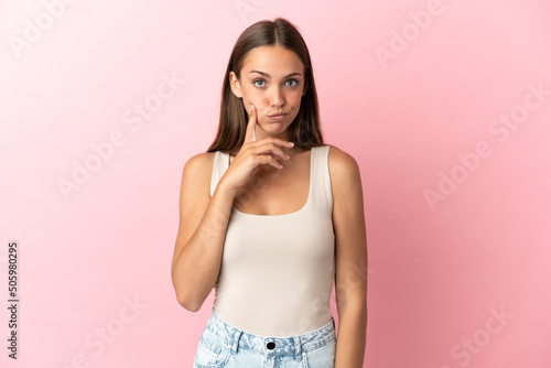 Young woman over isolated pink background and thinking