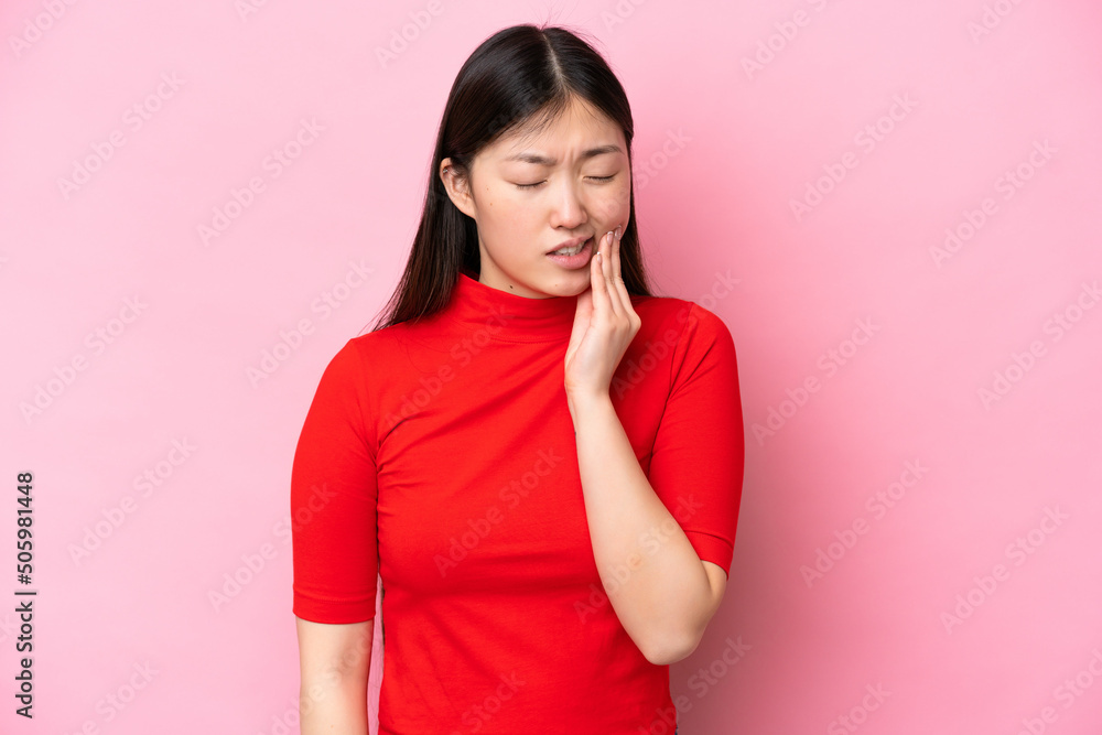 Young Chinese woman isolated on pink background with toothache Young Chinese woman isolated on pink background with toothache