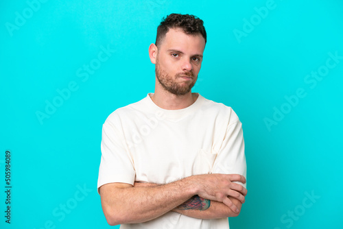 Young Brazilian man isolated on blue background feeling upset