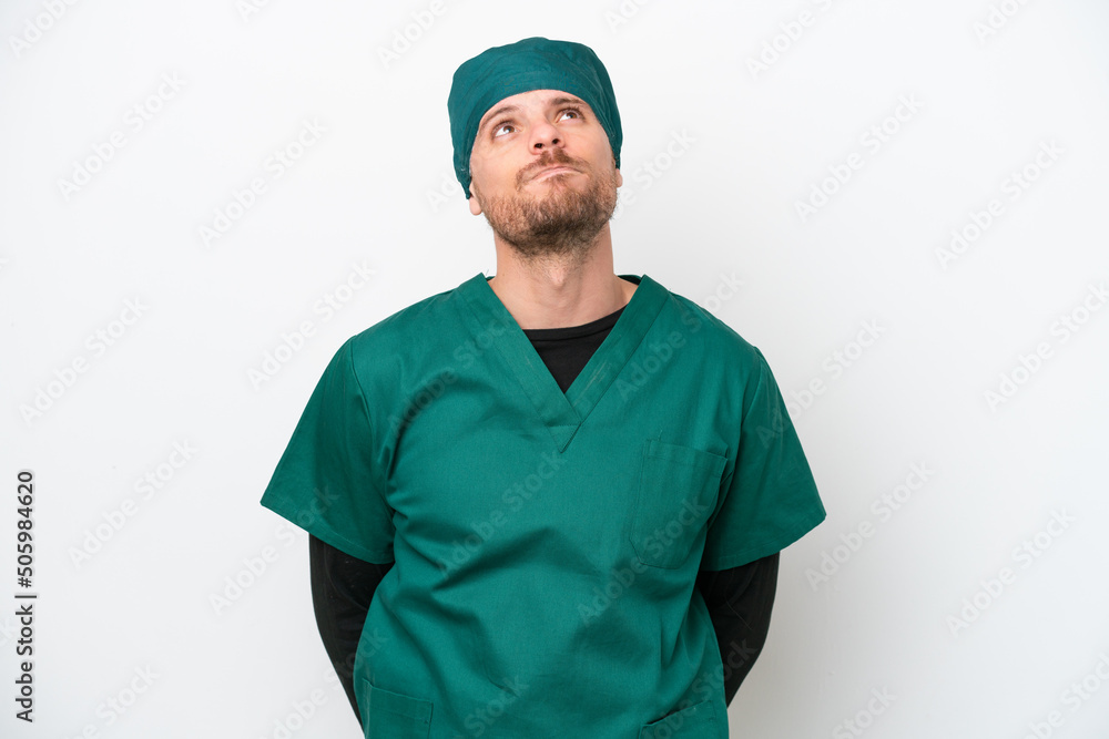Surgeon Brazilian man in green uniform isolated on white background and looking up Surgeon Brazilian man in green uniform isolated on white background and looking up