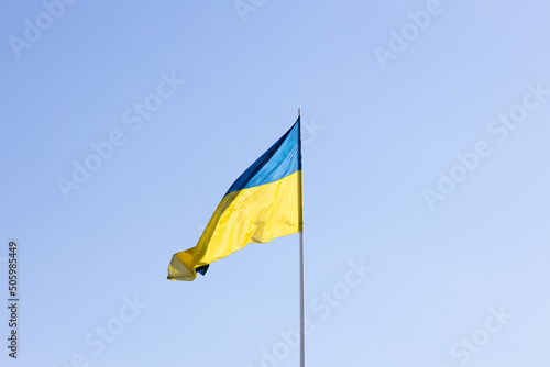 The state flag of Ukraine on a background of blue sky