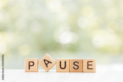 Wooden Blocks with the text: Pause on a green background photo
