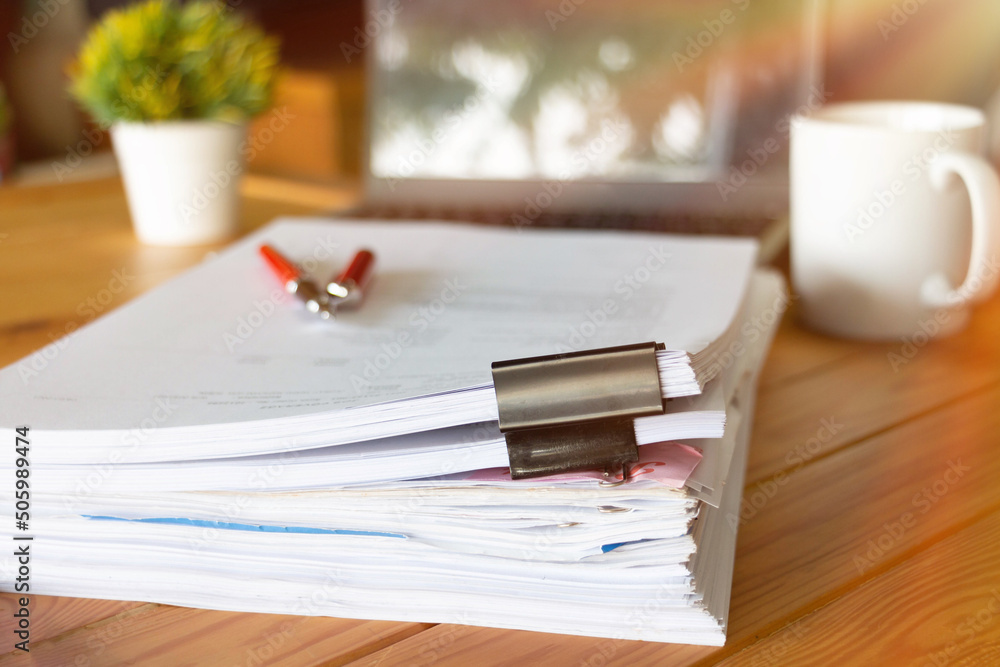 paperworks with black paperclips on top on wooden table paperworks with black paperclips on top on wooden table