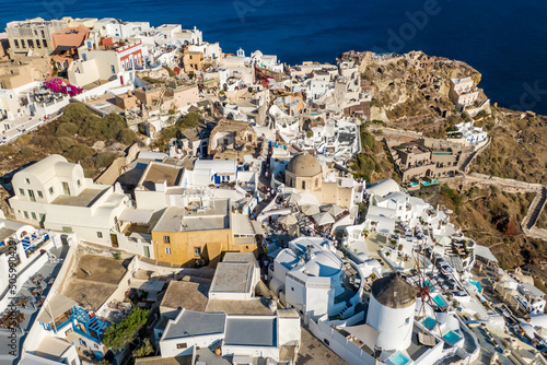 Traditional Greek white buildings in Oia, Santorini island. Aerial drone view.