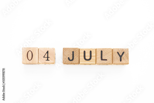 4 July. Independence Day. Calendar square cubes with shadows isolated on green summer background