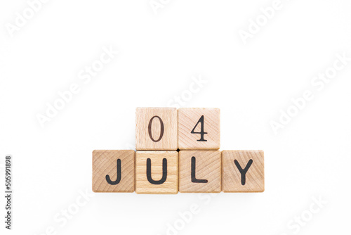 4 July. Independence Day. Calendar square cubes with shadows isolated on green summer background