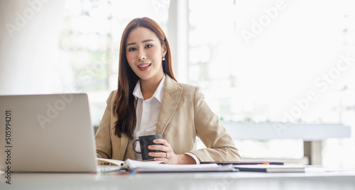 Asian woman working on laptop. Charming Asian Business woman busy working on laptop computer at the office.