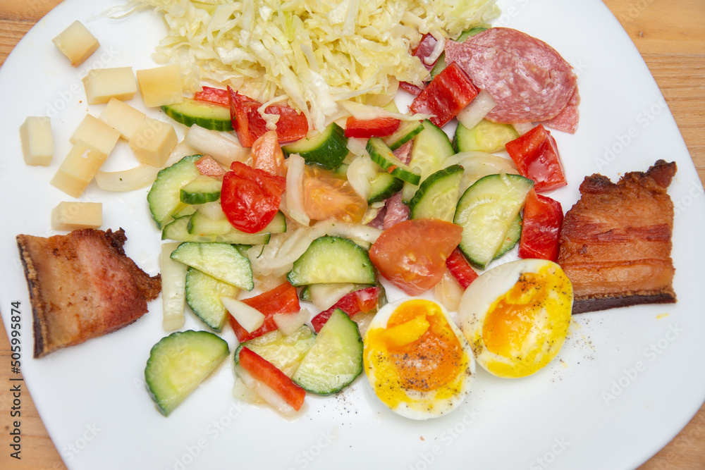 cold appetizer with boiled eggs, cucumber, salami, tomatoes and cheese cold appetizer with boiled eggs, cucumber, salami, tomatoes and cheese