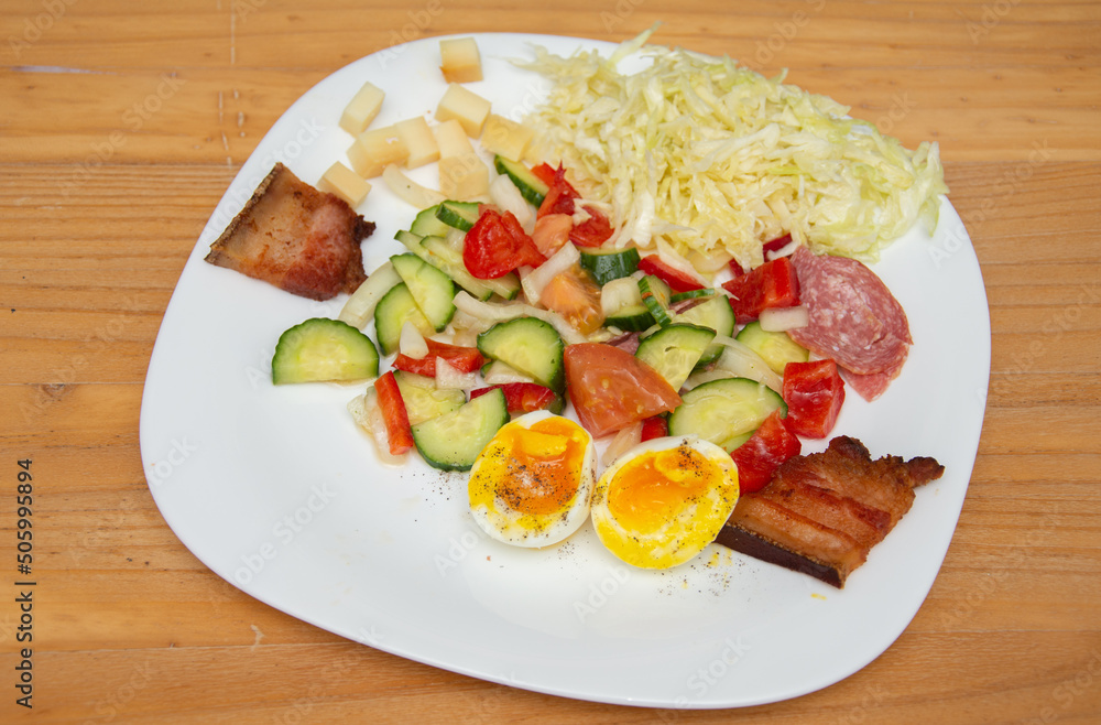 cold appetizer with boiled eggs, cucumber, salami, tomatoes and cheese